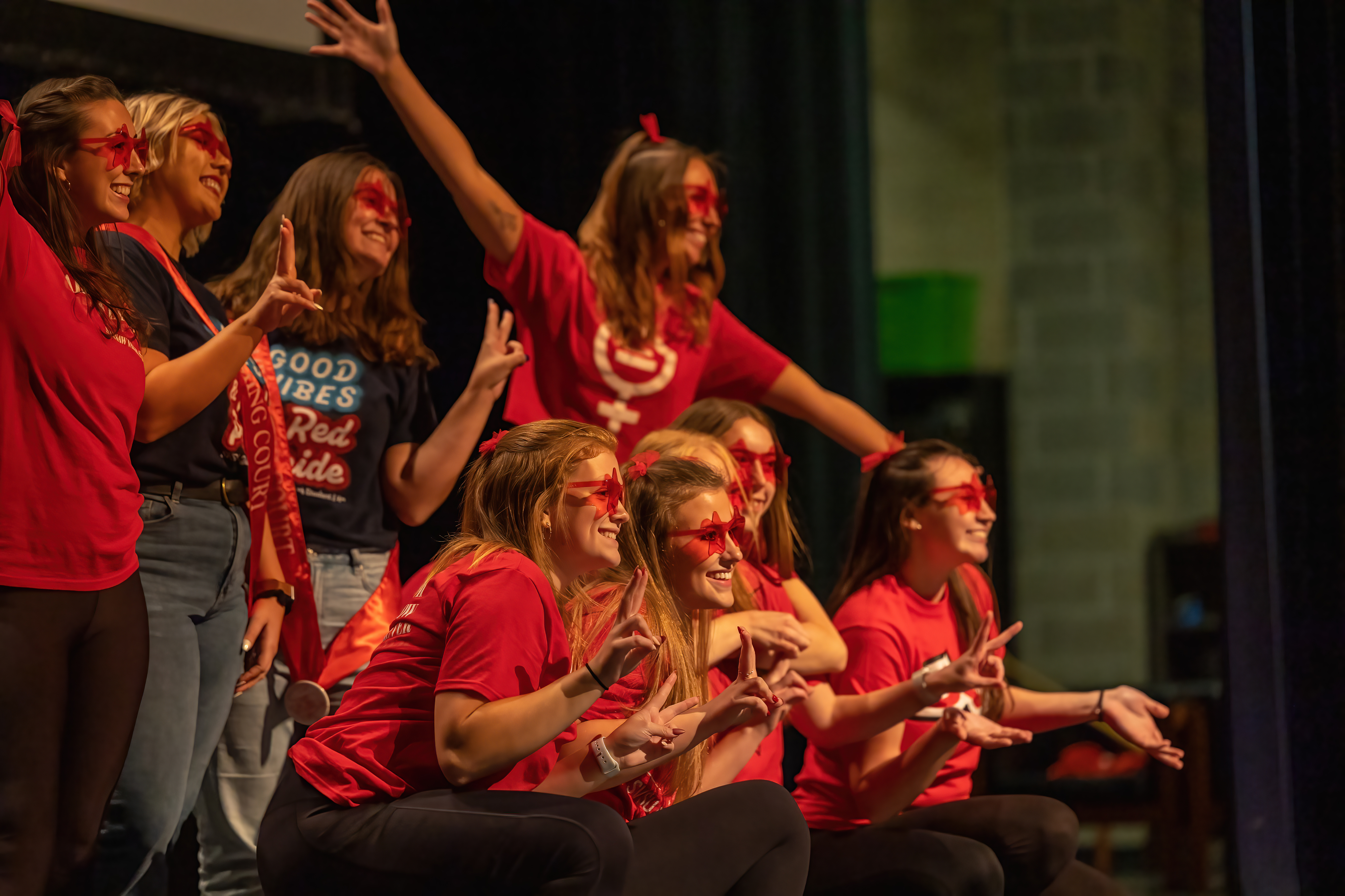 Students posing on stage in the Malcolm Field Theatre after concluding their lip sync performance.